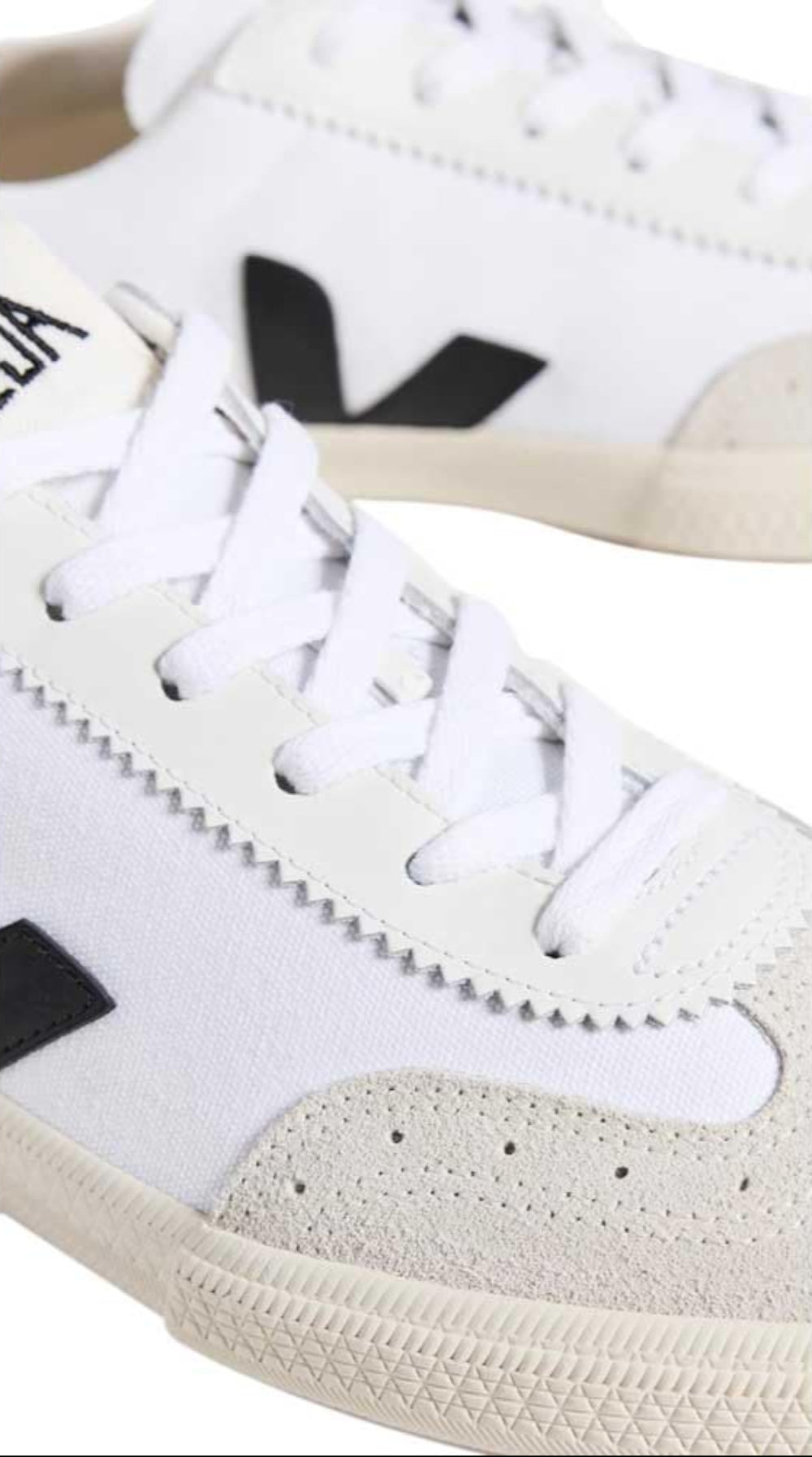 Close-up of a white sneaker with black logo on a white background