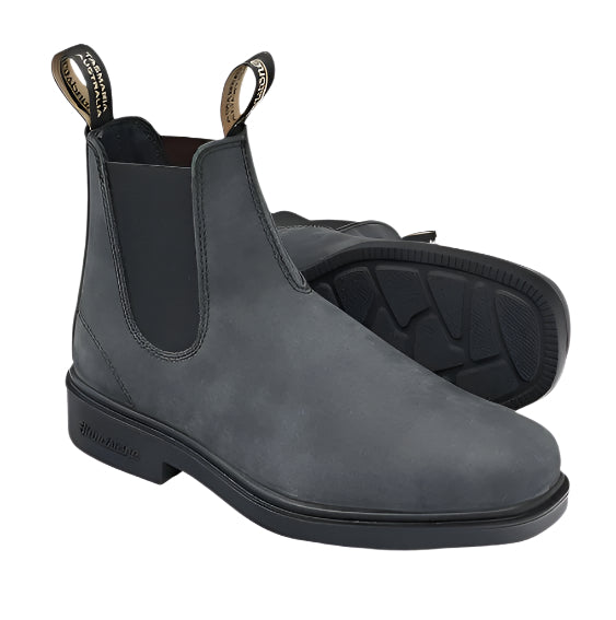 Pair of gray suede Chelsea boots on a light beige background
