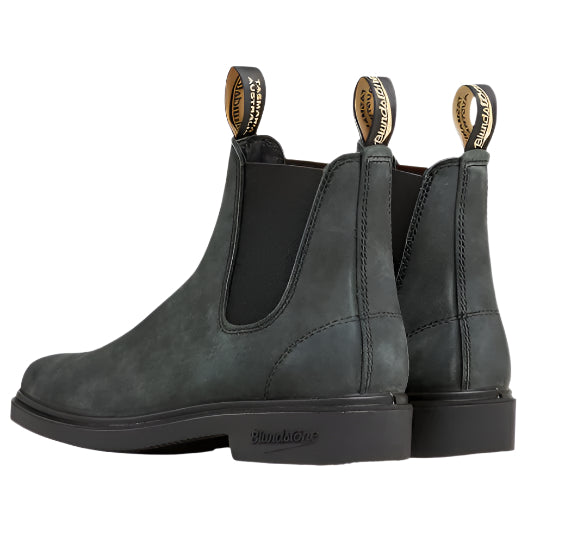 Pair of gray suede Chelsea boots on a light beige background