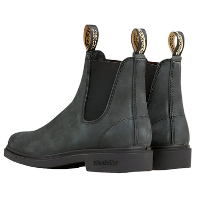 Pair of gray suede Chelsea boots on a light beige background