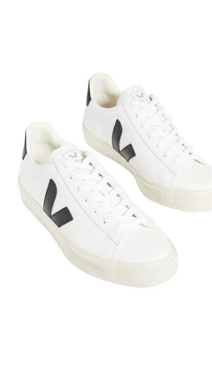 White sneakers with black logo on a white background