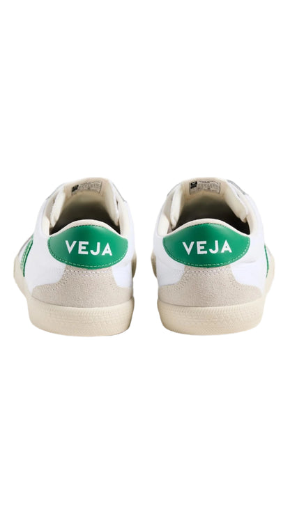 White sneakers with green 'Veja' logo on a white background